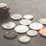 Home Assorted foreign coins stacked and scattered on a textured surface.